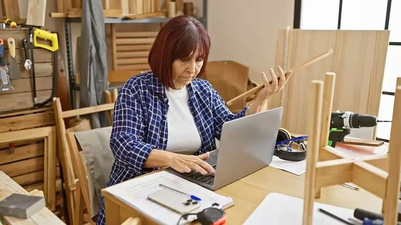 Person comparing travel costs on a laptop and notebook